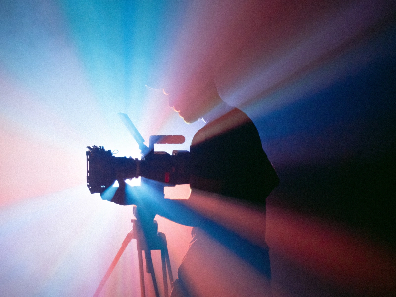 videographer using a recording camera with blue and red lights